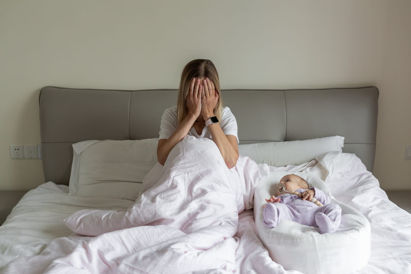 4 ay uyku gerilemesi yaşayan bebeğinin yanında yatakta yüzünü kapatarak ağlayan yorgun anne 4 ay uyku gerilemesi yaşayan bebeğinin yanında yatakta yüzünü kapatarak ağlayan yorgun anne