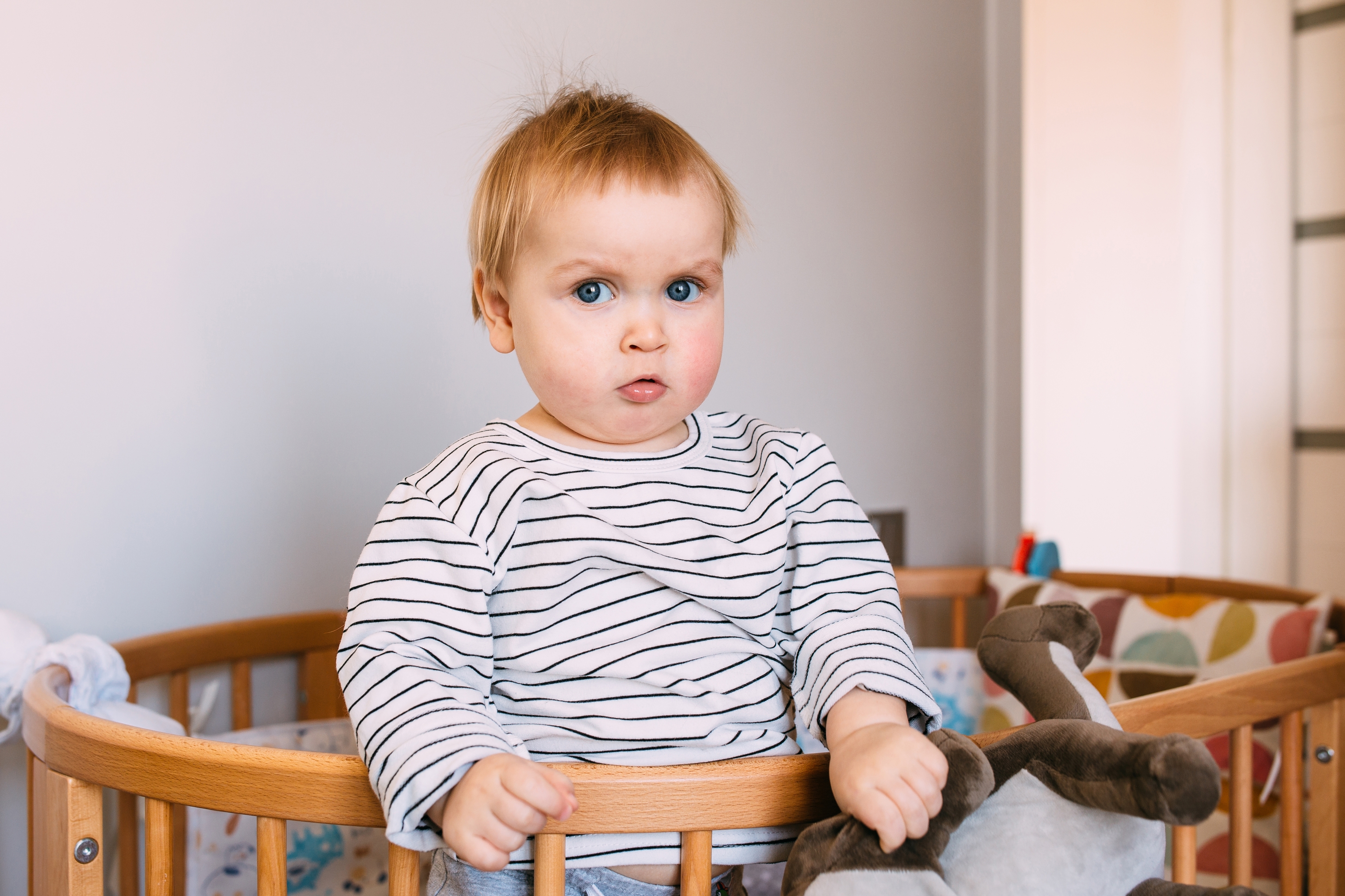 Baby standing in a crib before bedtime