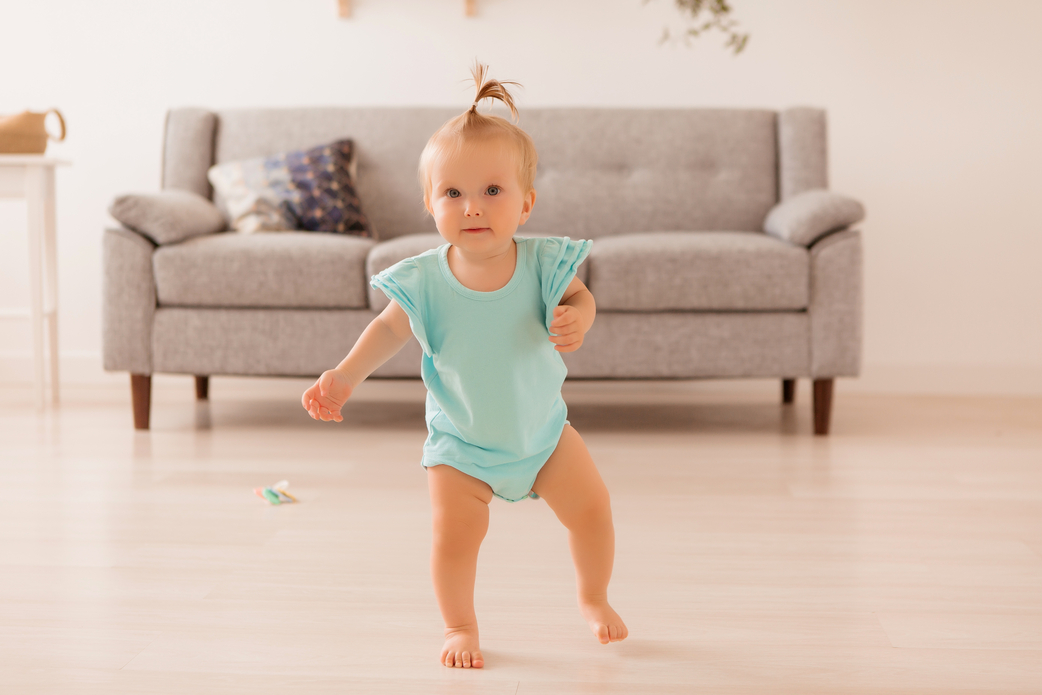 Toddler taking first steps in a bright living room