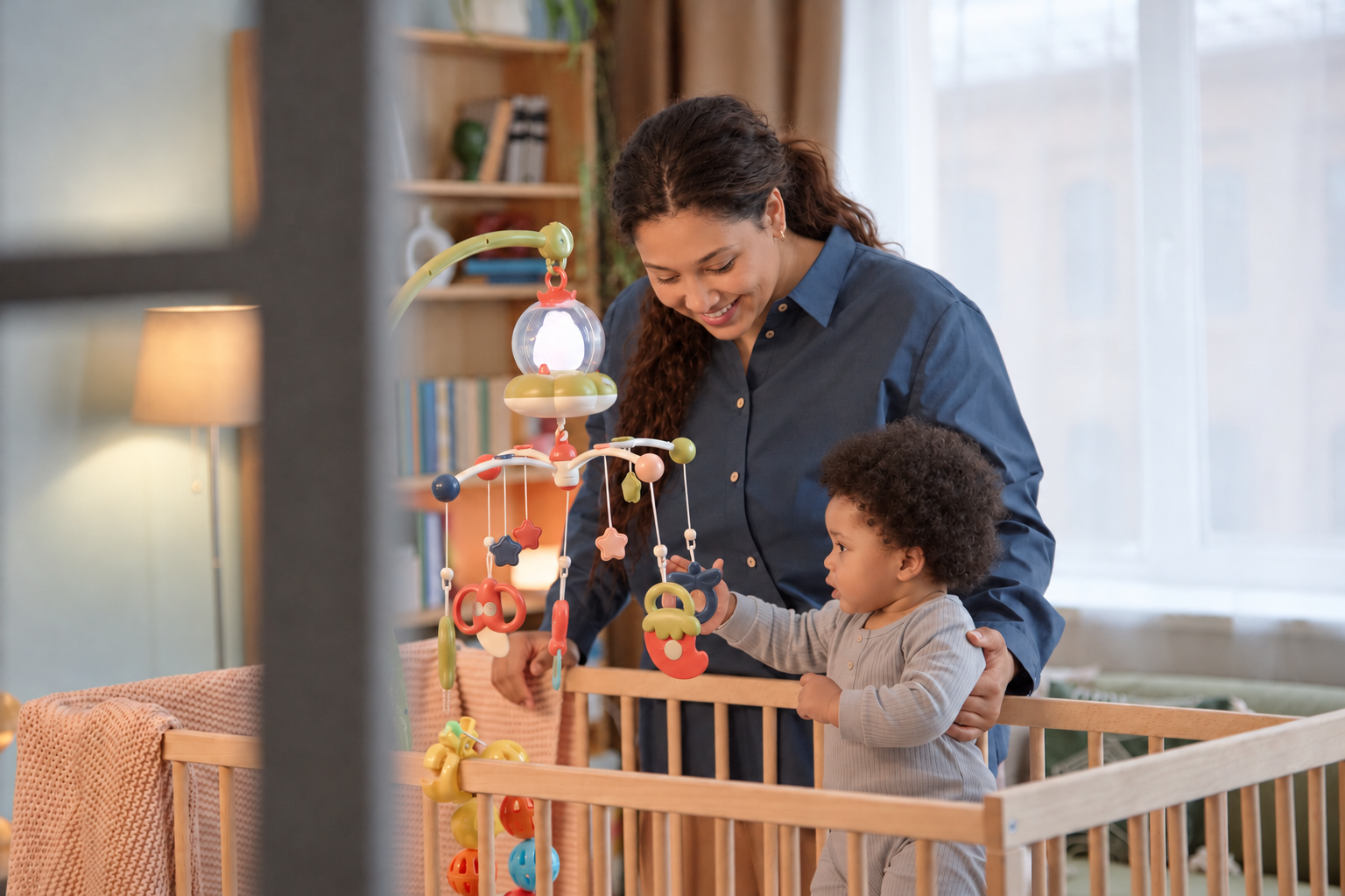 Parent sitting beside a toddler's crib in a softly lit nursery