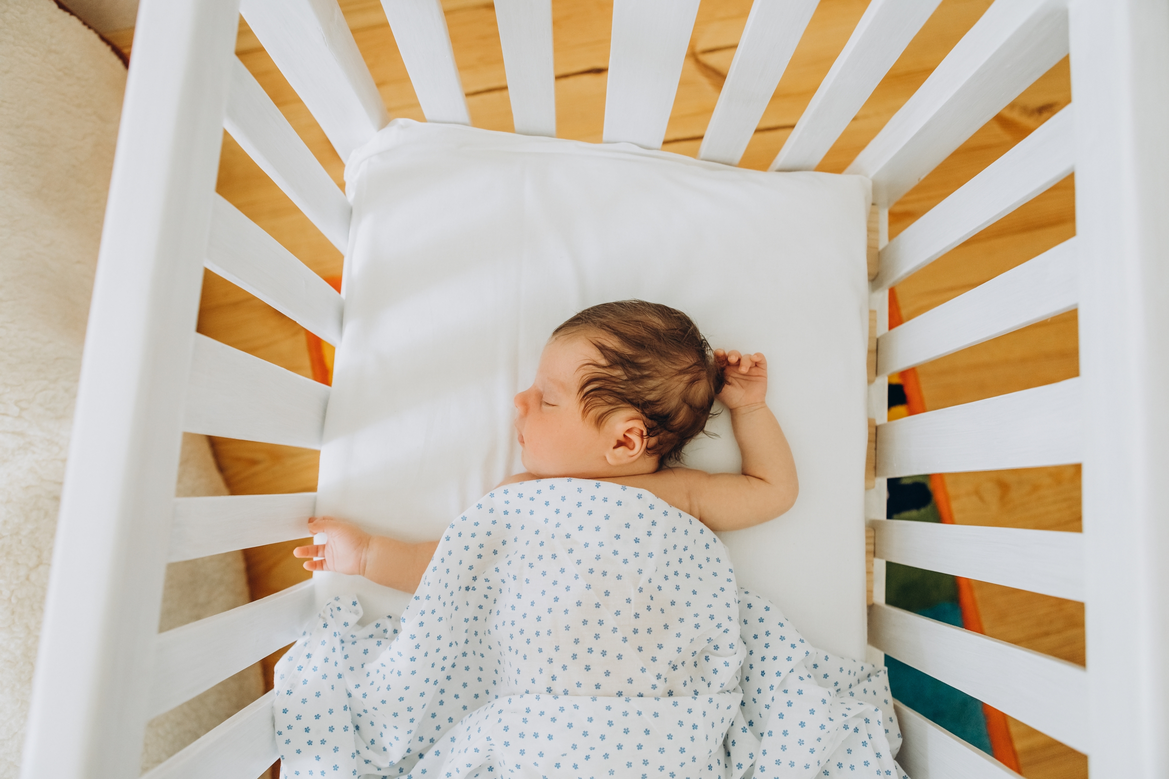 Baby taking a daytime nap in a clear crib