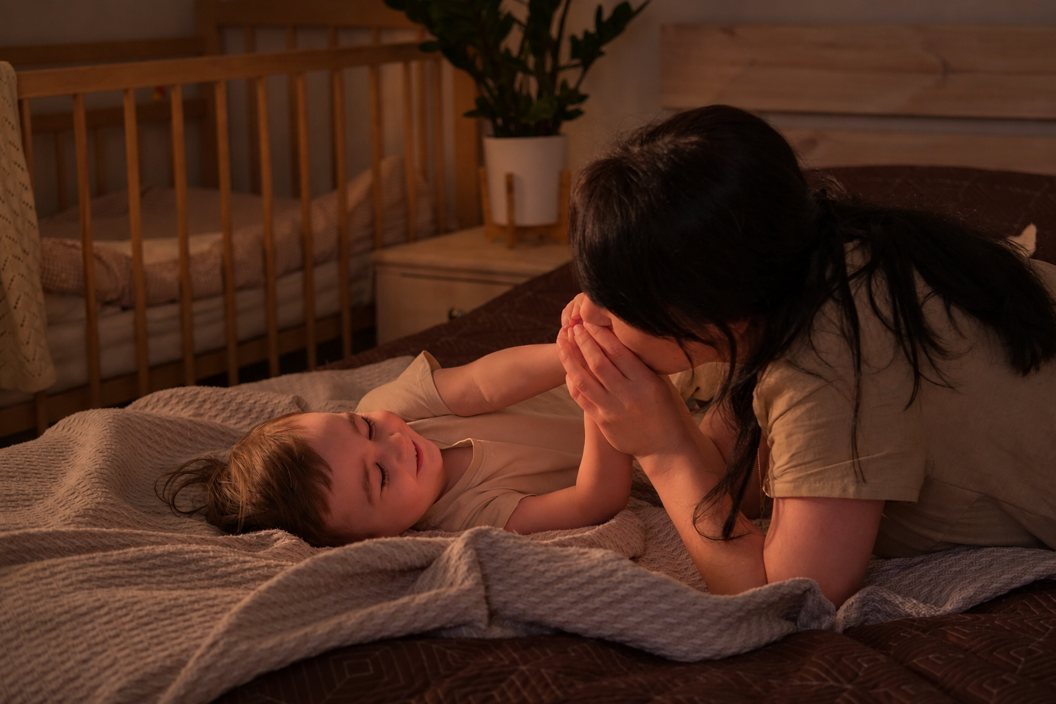Parent gently comforting a toddler beside a crib at night