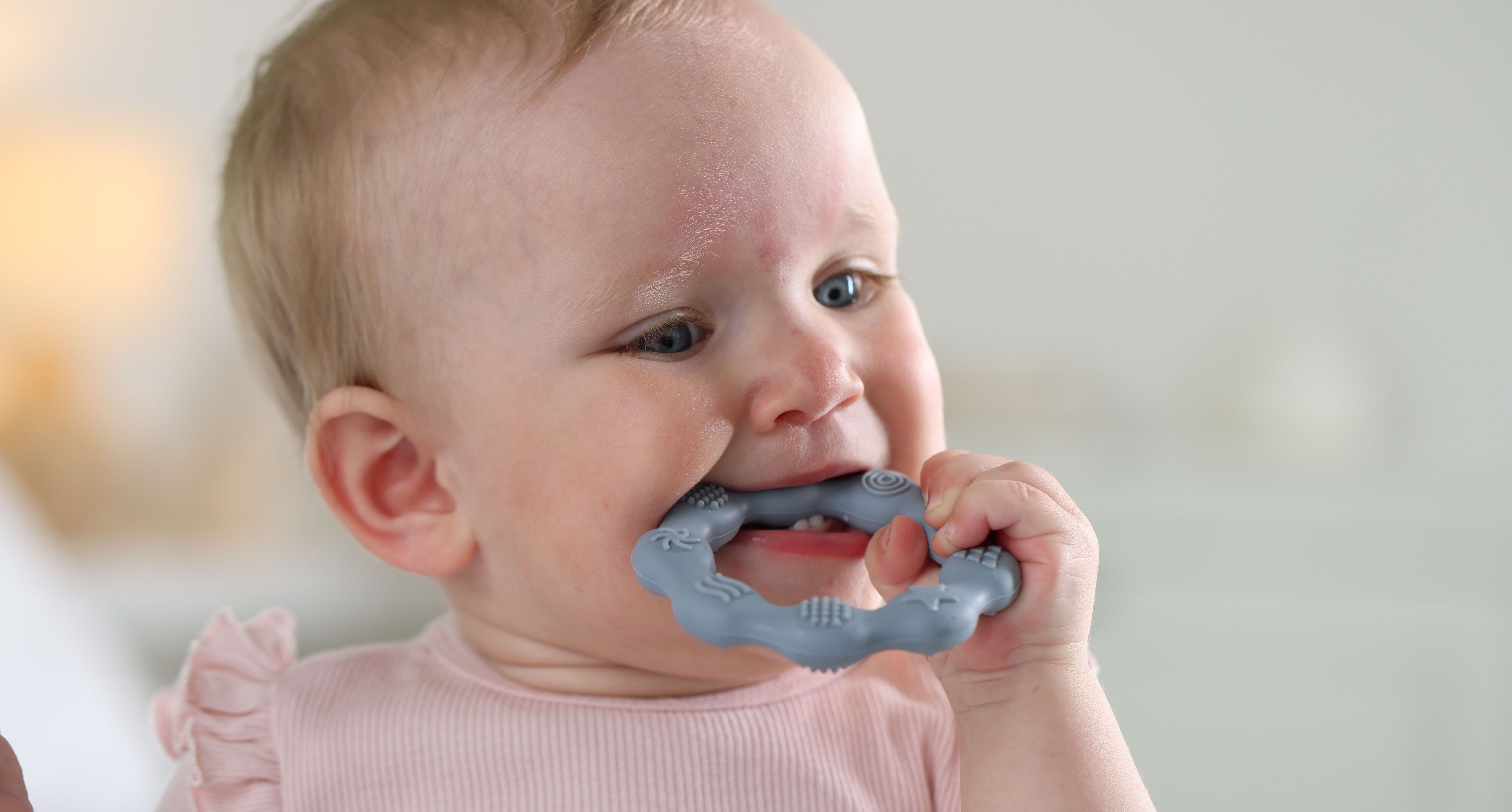 Baby chewing a plain teething ring
