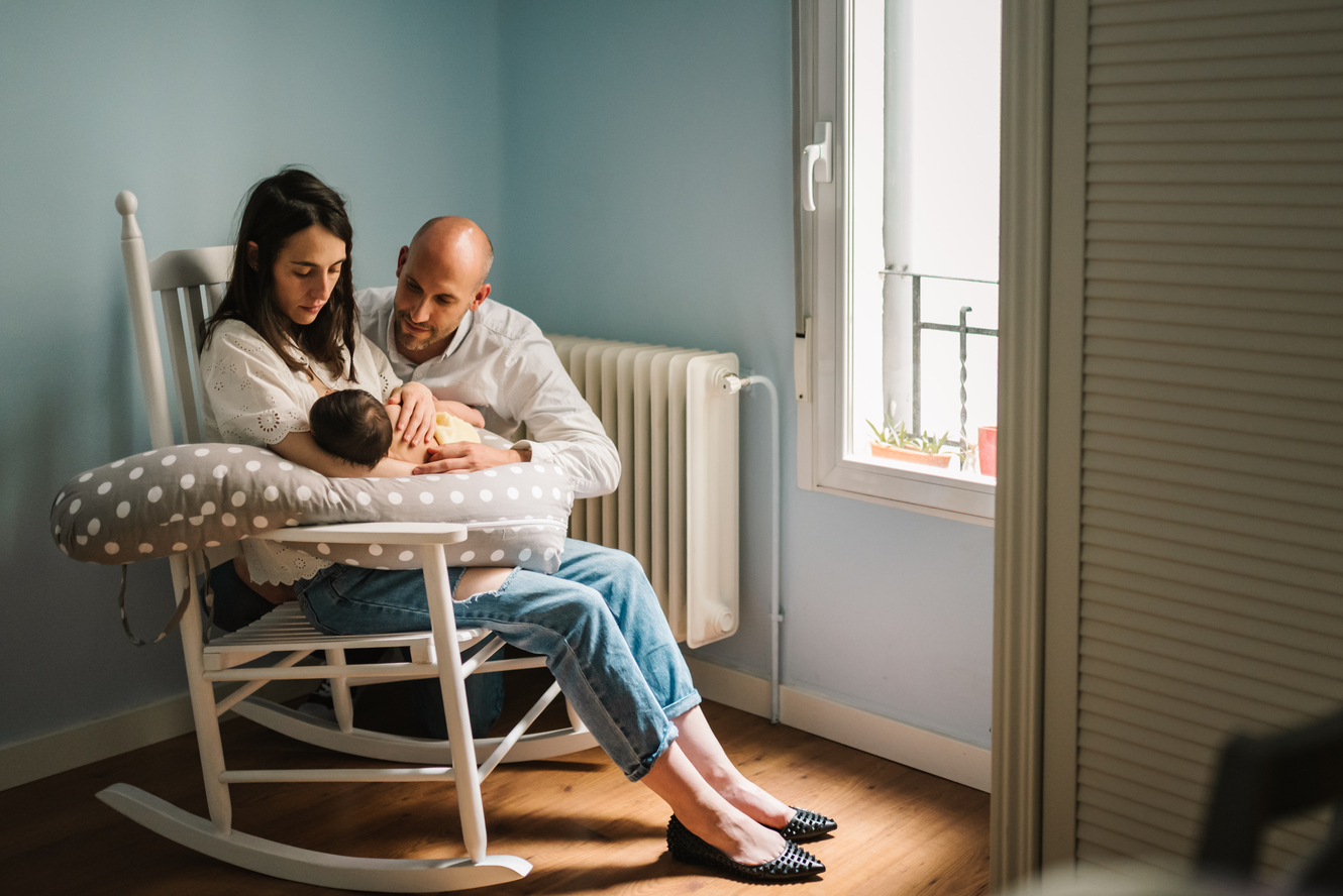 Parent gently comforting a fussy baby in a rocking chair