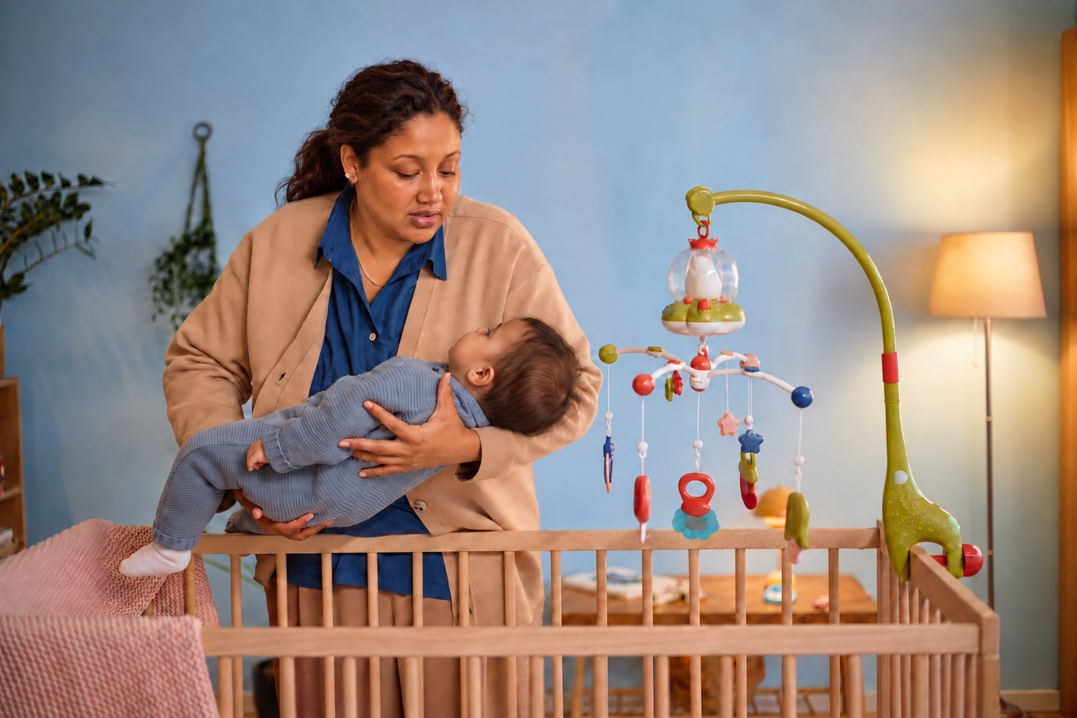 Parent gently patting baby's back in a dim nursery