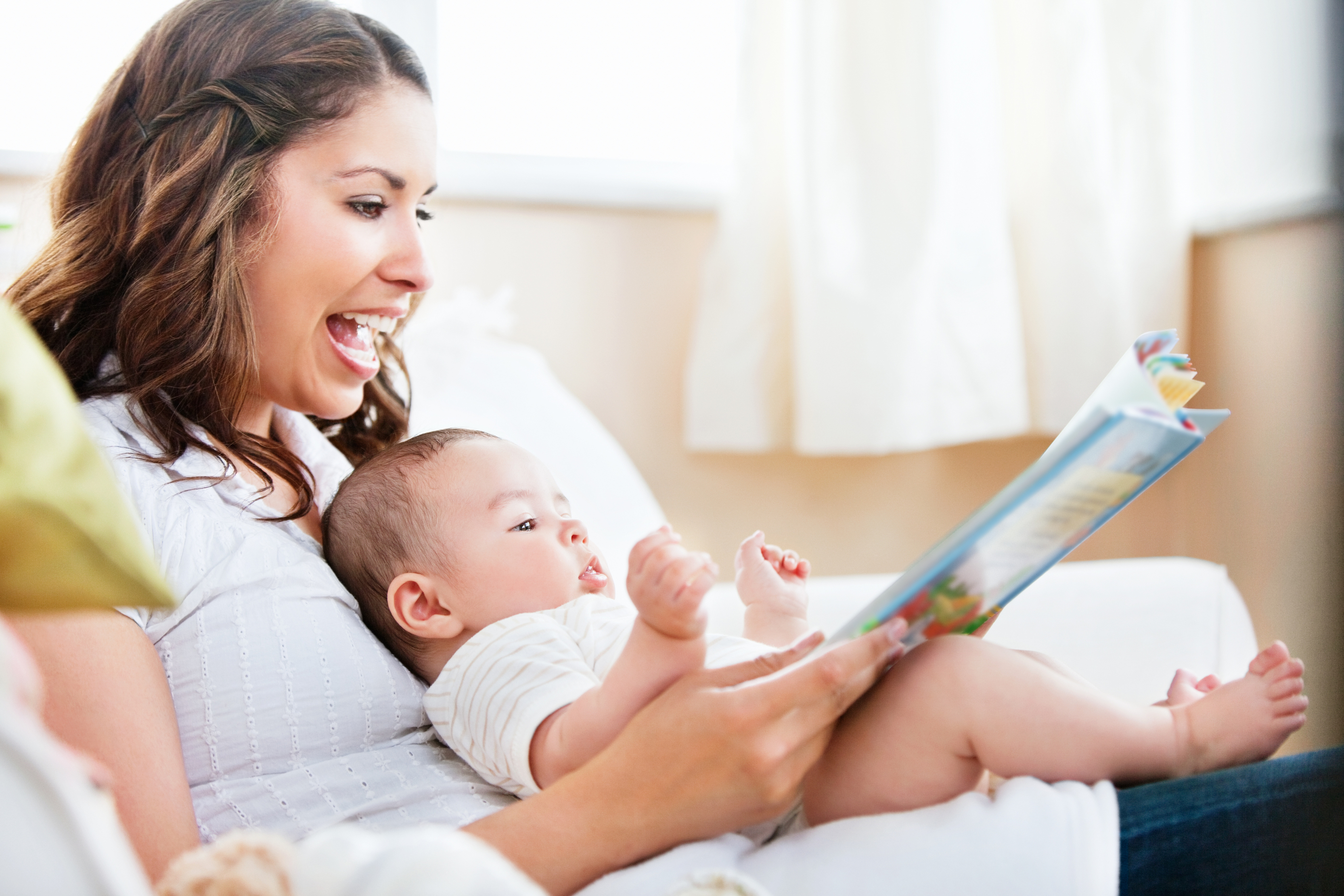 Parent reading a short board book to a baby before bed
