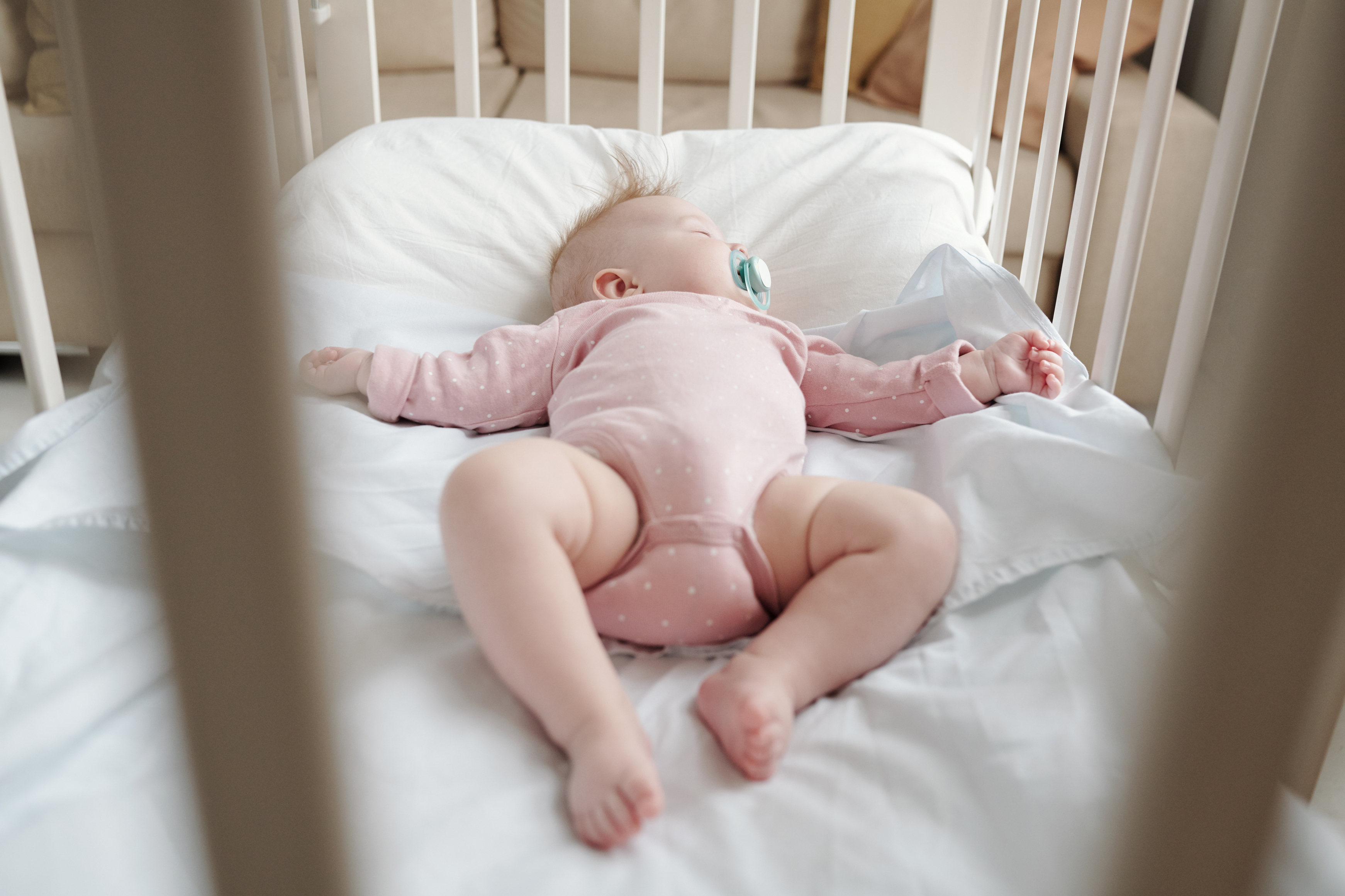 Baby sleeping safely in an empty crib